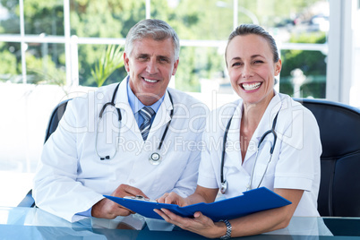 Smiling doctors working together on their file