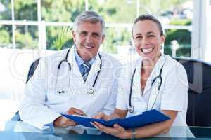 Smiling doctors working together on their file