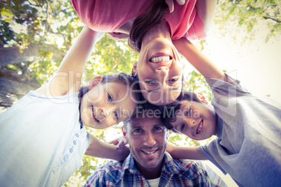 Happy family in the park huddling in circle