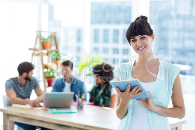 Smiling young businesswoman using tablet