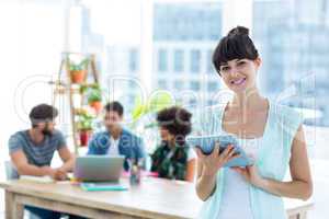 Smiling young businesswoman using tablet