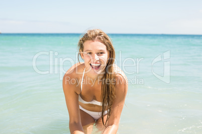 Happy pretty blonde looking at camera into the sea