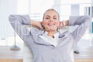 Smiling businesswoman relaxing on her office