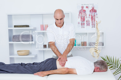 Physiotherapist doing back massage to his patient