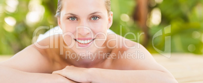 Peaceful blonde lying on towel smiling at camera