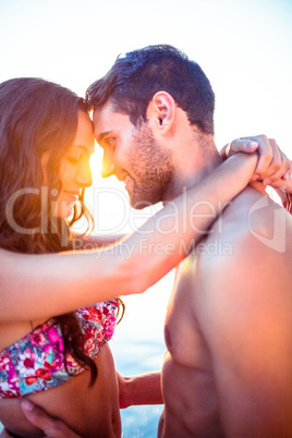 Smiling couple facing each other on the beach