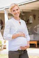Portrait smiling blonde pregnant hands on his belly