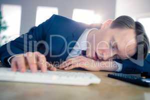 Exhausted businessman sleeping at his desk