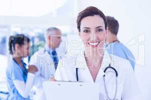 Confident female doctor holding clipboard