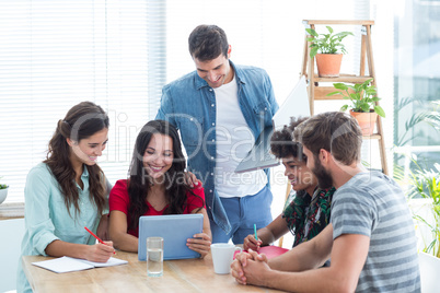 Creative business team gathered around a tablet