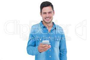 Hipster smiling at camera and using his smartphone