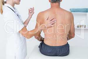 Doctor examining her patient back