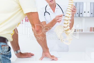 Doctor showing her patient a spine model