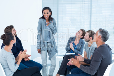 Rehab group applauding delighted woman standing up