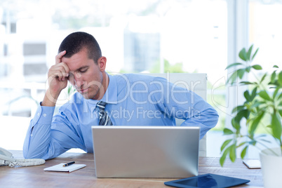 Worried businessman with head in one hand