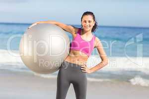 Happy fit woman holding exercise ball