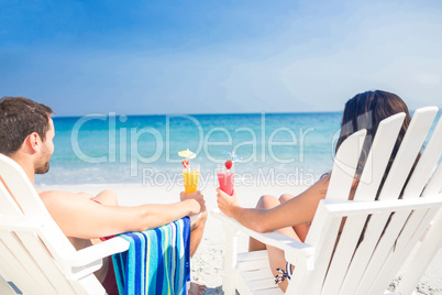 Rear view of happy couple drinking a cocktail together