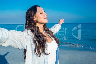 Happy woman with eyes closed at the beach