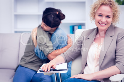 Smiling therapist with comforting patients in the background