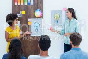 Casual young businesswoman giving presentation to colleagues