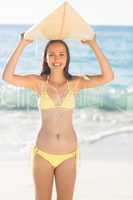 Pretty brunette holding surf board