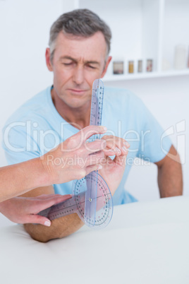 Doctor measuring arm with goniometer