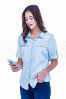 Pretty hipster with hand in pocket using her smartphone