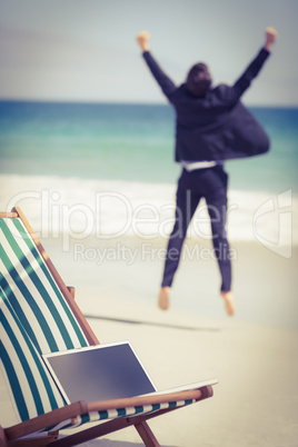 Excited businessman wearing suit jumping