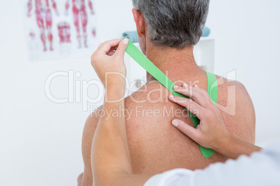 Doctor examining her patient shoulder