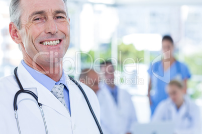 Smiling male doctor looking at camera with arms crossed