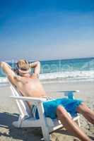 Man relaxing on deck chair at the beach