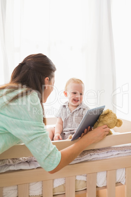 Happy mother using tablet with his baby boy