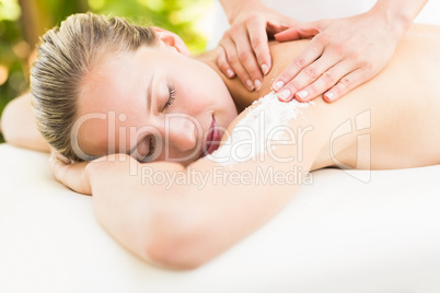 Attractive young woman receiving shoulder massage