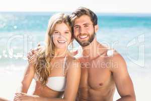 Happy couple relaxing together in the sand