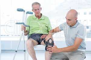 Doctor examining his patient knee