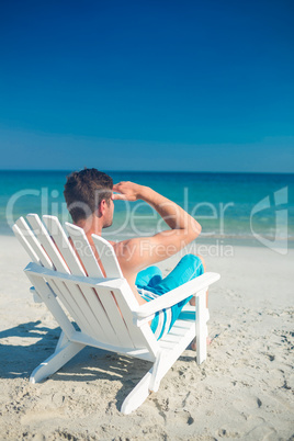 Man relaxing on deck chair at the beach