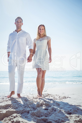 Couple holding hands and standing at beach