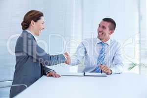 Smiling business partners shaking hand together