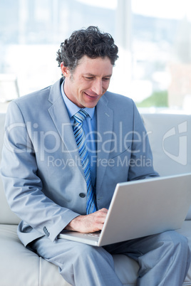 Businessman using his laptop on couch