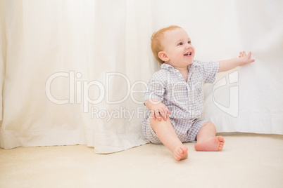 Cute baby boy sitting on floor