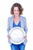 An anxious businesswoman holding clock