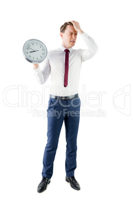 Anxious businessman holding a clock