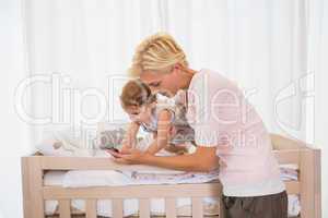 Happy blonde woman with his son using pohne