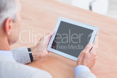 Concentrating businessman using a tablet