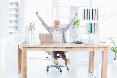 Happy businesswoman with raised arms