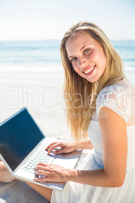 Woman using laptop and wearing hat