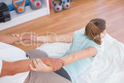 Woman stretching her arm with trainer