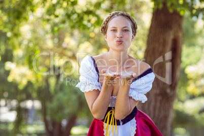 Pretty oktoberfest blonde blowing a kiss in the park