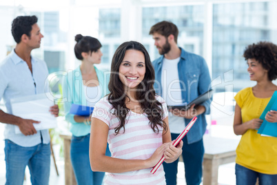 Casual woman with her colleague behind in the office