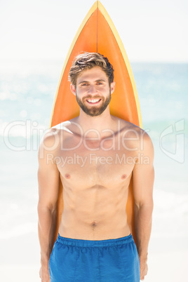 Handsome man holding surfboard